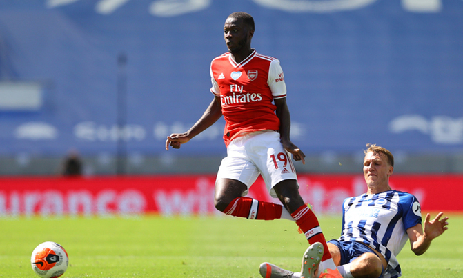 Arsenal's French-born Ivorian midfielder Nicolas Pepe (L) is tackled by Brighton's English defender Dan Burn. (AFP Photo)