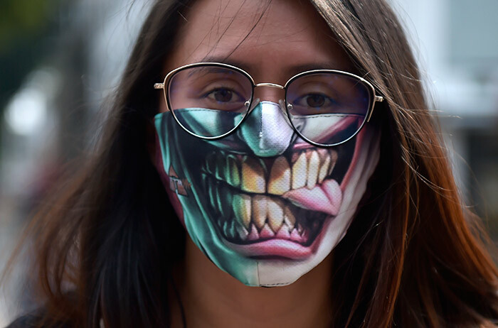 woman uses a face masks as a preventive measure against the spread of the new coronavirus 19 in ogota on arch 19 2020 olombia will block all international flights from onday for 30 days resident van uque announced on hursday hoto by aul
