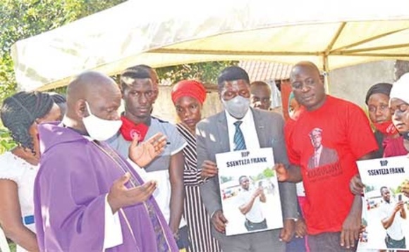 Fr. Ssentomero ng’ali ne bannakibiina kya NUP nga basabira omwoyo gw’omugenzi Ssenteza. Mu ssuuti ye Balimwezo, addiriddwa Paul Mugambe. Ku ddyo ye Faizo Kibirige. Fr. Ssentomero ng’ali ne bannakibiina kya NUP nga basabira omwoyo gw’omugenzi Ssenteza. Mu ssuuti ye Balimwezo, addiriddwa Paul Mugambe. Ku ddyo ye Faizo Kibirige.