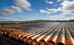  Oil and gas pipeline or production tubing stacked with threads cleaned and gleaming in the late sun ready to be connected and run down hole in WA