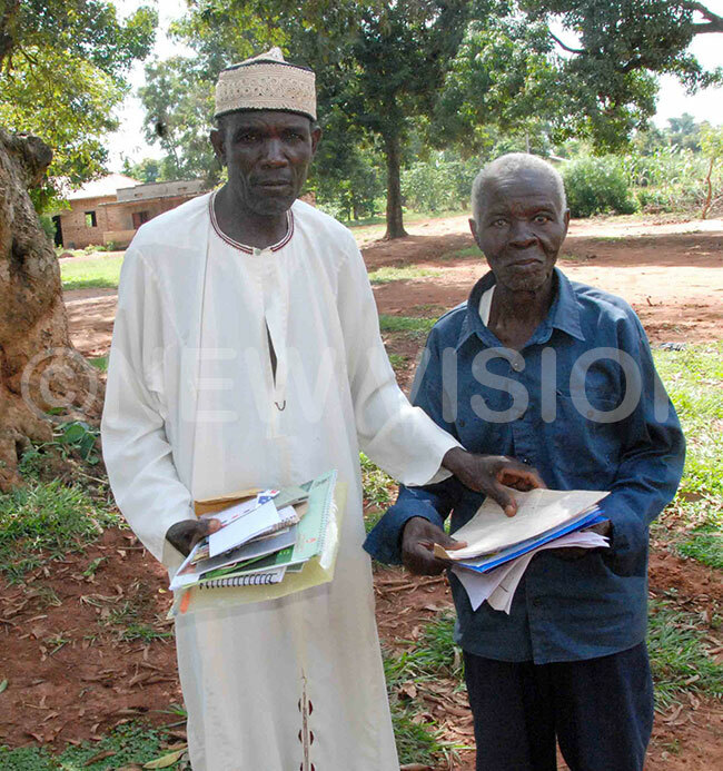  eft to righthe mam of ukapala asjid ainabu heikh li sempa  and chairman of the osque sheikh waibu aiswa showing the documents of the osque during interviews with the ew ision recently 