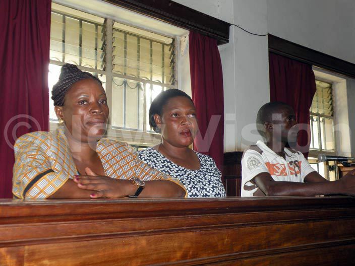   arah abikolo wife to the late ria ebunnya ugembe aka asiwukira her sister andra akungu and shiraf adin the suspects in asiwukira death in the dock at igh ourt on arch 30 2015 hoto by amadhan bbey    