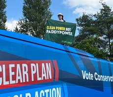 'Clean Power Not Paddy Power': Greenpeace protester climbs on to Tory campaign battle bus