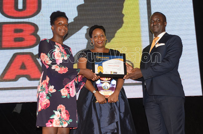  aphne ashobya center and her daughter pick former  president mbrose ashobyas ward from  president asser serunjogi at the awards dinner at abira ountry lub pril 7 2019 hoto by ichael subuga