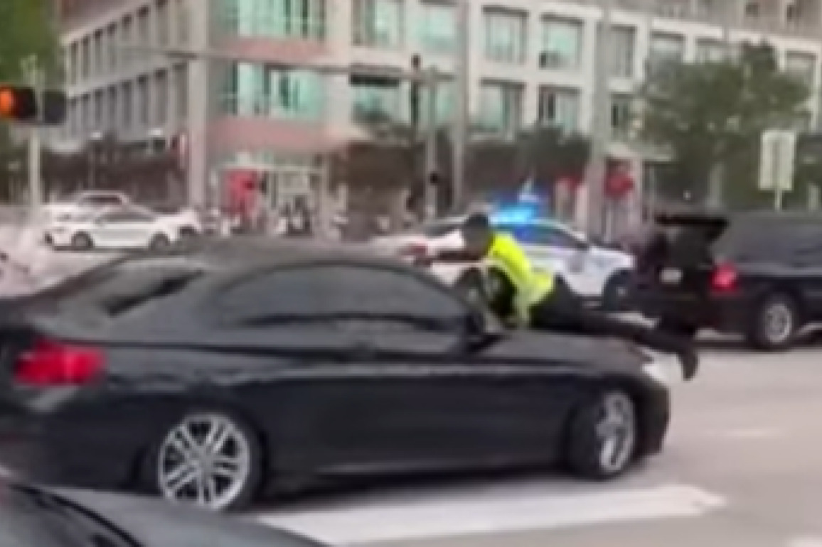 Miami Police officer shoots through windshield while clinging to car's hood in viral video