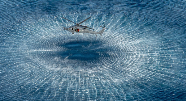 An airman pulls a ladder into an HH-60W Jolly Green II helicopter during a simulated rescue operation as part of Exercise Distant Fury Stallion/Steel Knight off the coast of California, Dec. 9, 2024