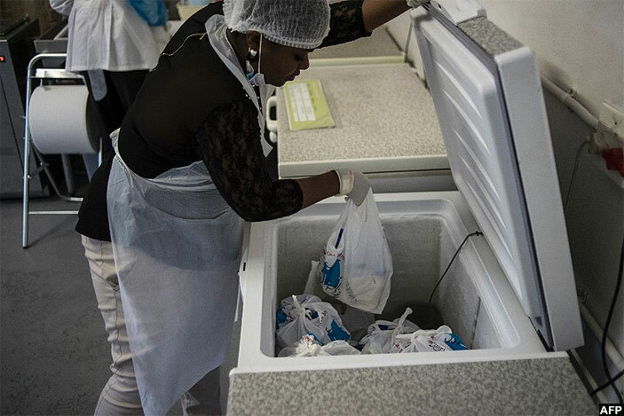   staff member of the outh frican reastmilk eserve  in ohannesburg packs unpasteurised donated breast milk into a freezer