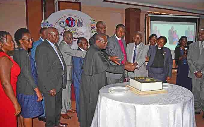  rchbishop tanley tagali cutting  a cake with members of the oard of the ible ociety of ganda during his farewell breakfast at ilver pring otel ugoloobi on riday ebruary 7 hoto by athias azinga