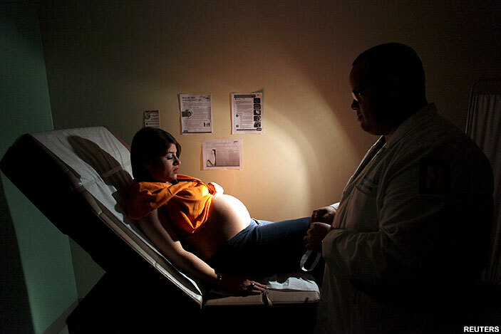  oriany ivera who is 40 weeks pregnant looks at her belly as she listens to a doctor during a routine check up as fliers explaining how to prevent ika engue and hikungunya viruses are posted on the wall at a public hospital in an uan uerto ico