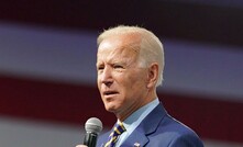 File photo: US President Joe Biden speaks in front of a large flag