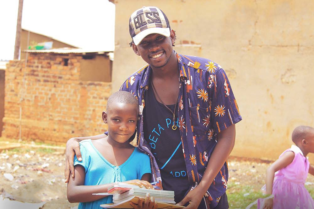  evixone hands over books to a school child