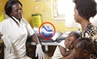 Health workers use the handheld, touch-screen Deki Readers (circled)
