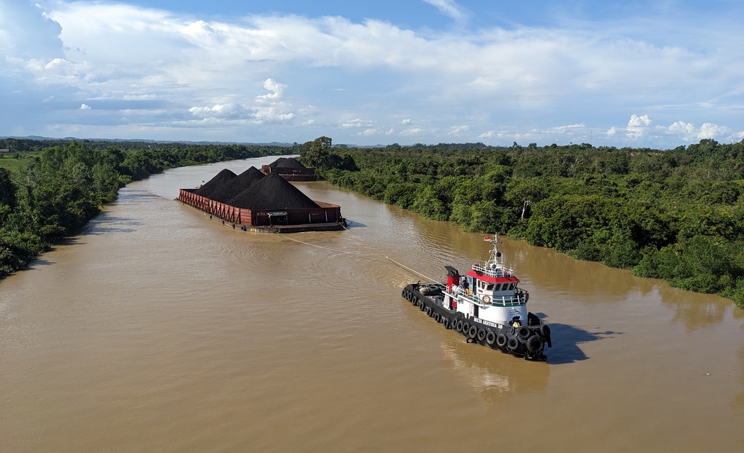 Samarinda, Indonesia: Tugboats tow coal barges on the Mahakam tributary.