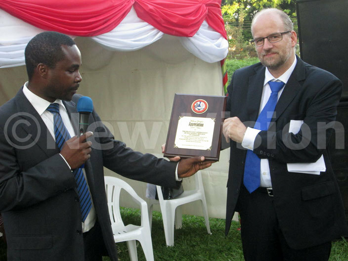  ubaga ospitals xecutive irector octor ndrew sekitoolekoleft hands an award of appreciation  to do eber during the commissioning  