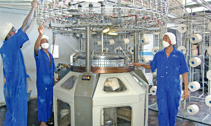 orkers in a factory operating machinery which stretches yarn used for fishnets