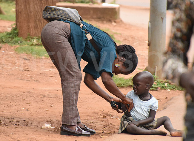   woman gives money to a street kid along inja oad 