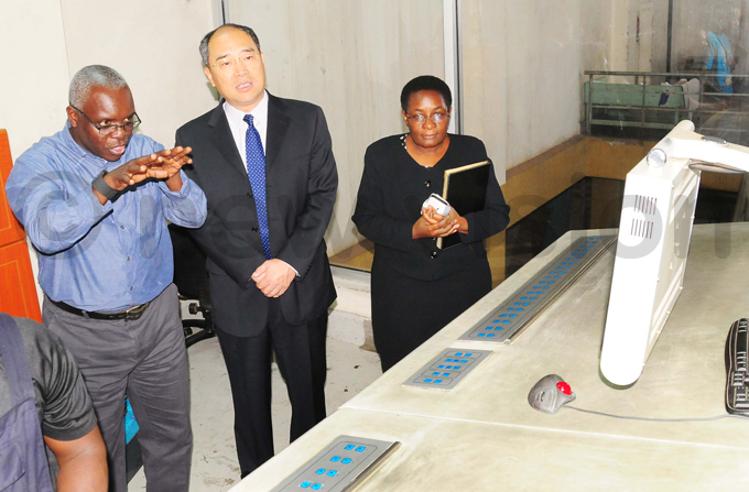 abushenga explains how the machines in the printery to mb huqiang while aija looks on during a tour of the ision roup head offices  hoto by icholas neal