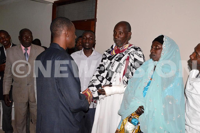  elfstyled king of nkole mar simweleft shaking hands with his father drisa aweesa after reconciling with him aweesa who had disowned his son and dethroned him as king has been involved in a dispute with his son over the throne hoto by dolf yoreka