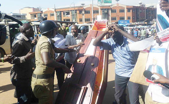 Abatembeeyi nga batwala ssanduuke n'abaserikale nga babalemesa okugitwala. Abatembeeyi nga batwala ssanduuke n'abaserikale nga babalemesa okugitwala.