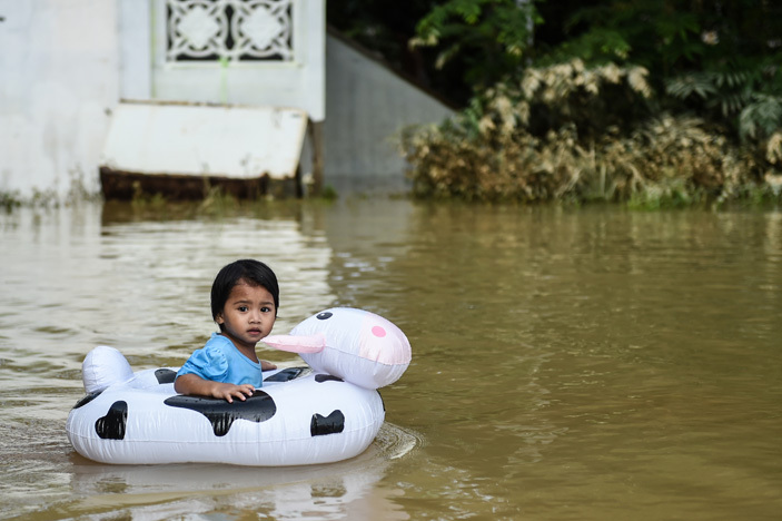   girl plays in floodwaters in alaysias northeastern town of antau anjang which borders hailand on anuary 5 2017