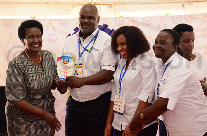 rade minister melia yambadde hands over an ward to officials from ganda ommunications ommission hoto by ddie sejjoba