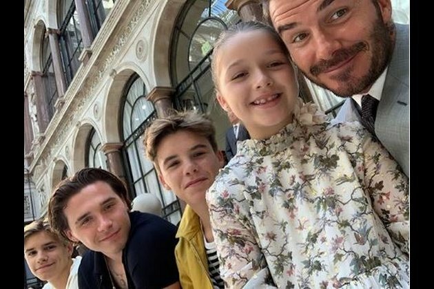 David Beckham cheers for wife Victoria with their kids