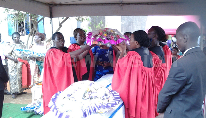  hoir members of hrists athedral ugembe where ambago belonged laying a wreath on his casket on uesday