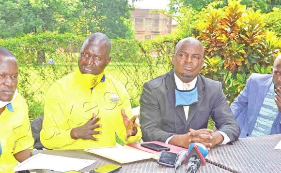 Achile (owookubiri ku kkono) ng’ayogera eri bannamawulire. Asooka ku kkono ye Kyomya ate owookubiri ku ddyo ye Mandera Nsubuga. Achile (owookubiri ku kkono) ng’ayogera eri bannamawulire. Asooka ku kkono ye Kyomya ate owookubiri ku ddyo ye Mandera Nsubuga.