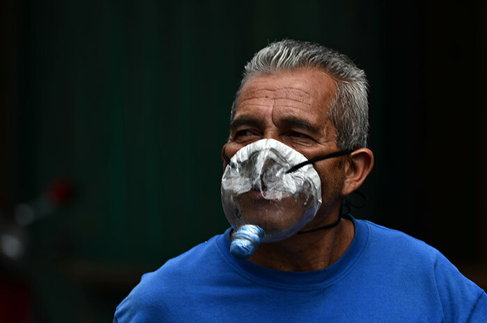 man wears a makeshift face mask made from a plastic bottle against the spread of the new coronavirus as he walks along an avenue in downtown in egucigalpa on arch 22 2020 uthorities have confirmed 26 cases of 19 in the country so far hoto by