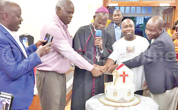 Bp. Sekamaanya n’abamu ku Bannayuganda abali e Bungereza nga basala keeki. Bp. Sekamaanya n’abamu ku Bannayuganda abali e Bungereza nga basala keeki.