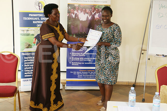  rincipal ducation fficer in the inistry of ducation and ports ary tete unteese  gives a certificate of attendance to one of the teachers usan pok hoto by ilson anishimwe