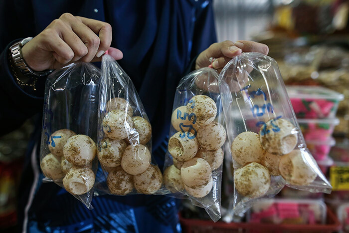   vendor poses with turtle eggs for sale at a market in uala erengganu on ay 21 2020   alaysian state that is a major turtles nesting site will ban the trade in their eggs authorities said ay 21 2020 in a major boost for the rare creatures hoto by   