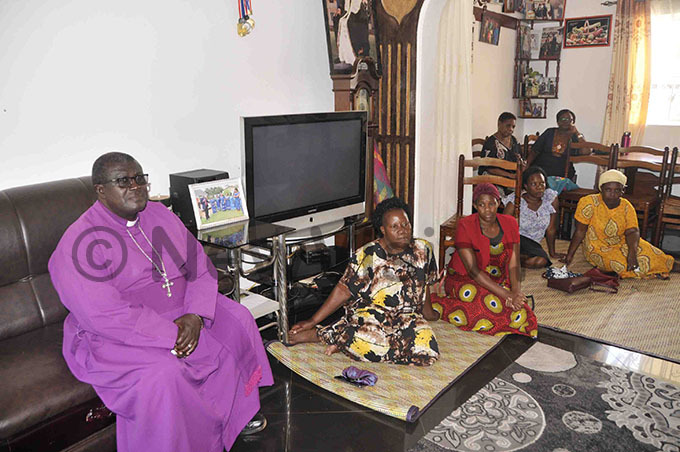 p ackson atovu of entral uganda diocese with other mourners at igongos home on ednesday hoto by enry subuga