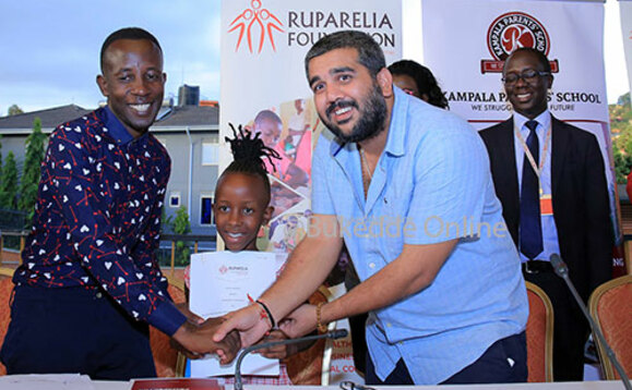 Rajiv ng'amaze okuteeka emikono ku mpapula ne taata wa Felisita Rajiv ng'amaze okuteeka emikono ku mpapula ne taata wa Felisita