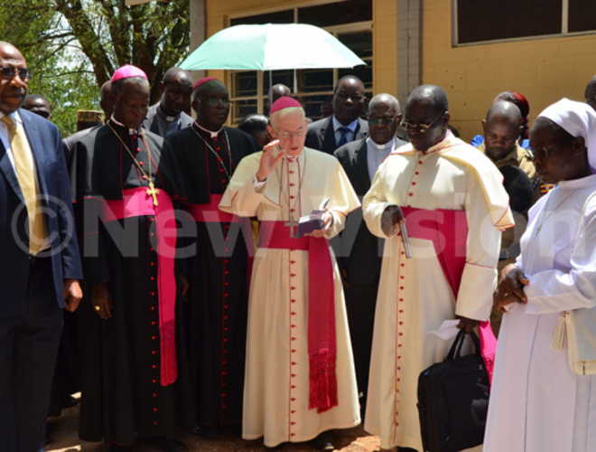  rchbishop lume prays for the students new dormitory as rime inister ugunda looks on