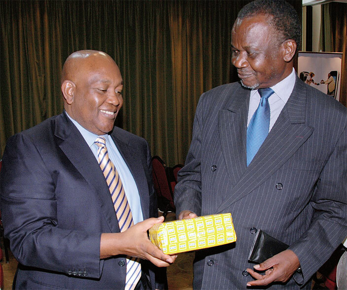  chairman harles bire left hands over a lack erry smartphone to the then information minister ggrey wori during the commercial launch of  mobile money at heraton ampala otel in 2009
