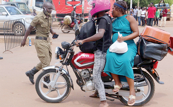 Abapoliisi nga bagezaako okutangira owabooda aweese omukazi woolubuto n’emigugu. Abapoliisi nga bagezaako okutangira owabooda aweese omukazi woolubuto n’emigugu.