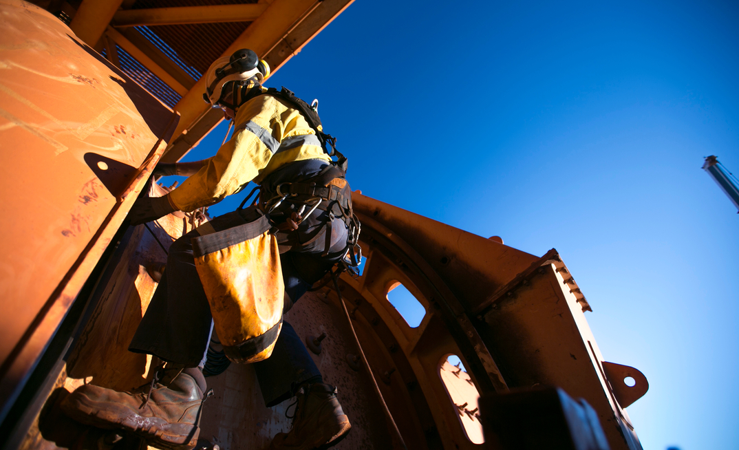 Rope access mine worker at construction iron ore mine site in Pilbara, Australia