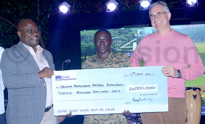 ransport state minister ggrey agiire left and homas reyssig from the ermany mbassy presents the sh20m professionals cheque to overall winner ichard aguma hoto by ichael subuga