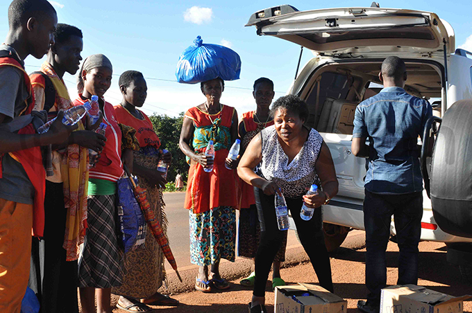 nalongo alumba gives water to pilgrims making their way to amugongo hoto by uliet ukwago
