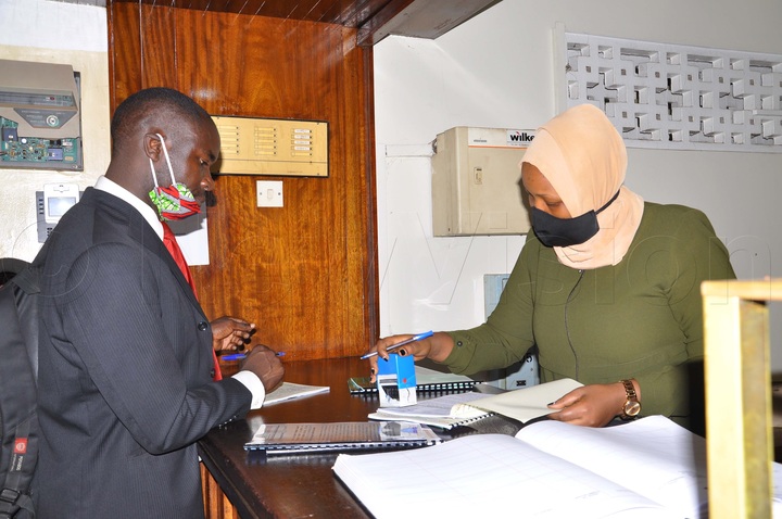 Mabirizi (left) filing his petition at Buganda Road Court on Monday. Photos by Nancy Nanyonga