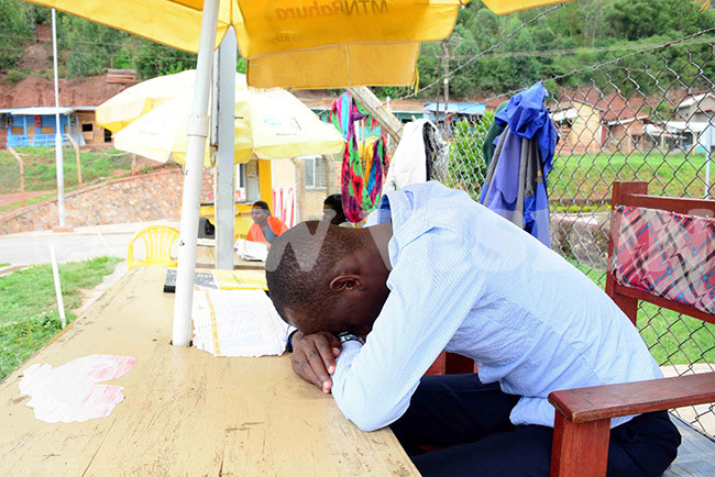   mobile money dealer sleeps on his desk after waiting for customers in vain