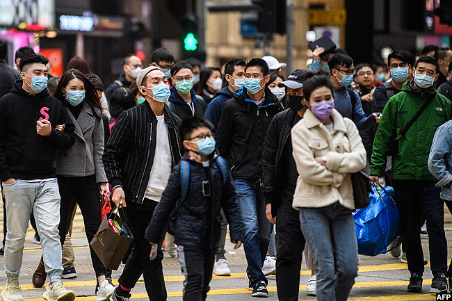  edestrians wearing face masks cross a road during a unar ew ear of the at public holiday in ong ong