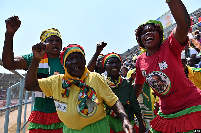  omen dressed in colours of the ruling  party dance on hursday at the ufaro stadium in arare