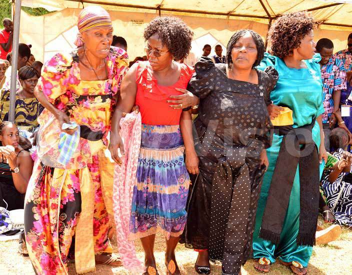  he late tephen aweesas widow arah aweesa second right supported by relatives to walk during the funeral service at esu kwagalas chuch in eguku on uesday arch 29 2016 hoto by hamim aad