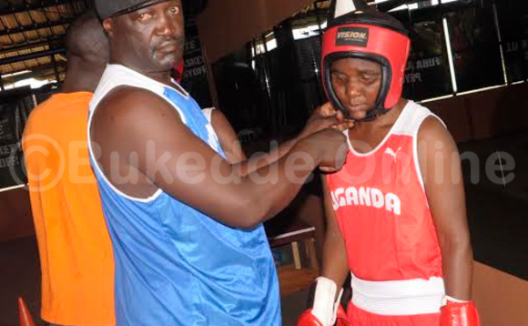 Omugenzi Dick Katende abadde omutendesi w'ebikonde (ku kkono) ng'ayambako omuzannyi okwambala gaadi y'okumutwe.(STEPHEN MAYAMBA) Omugenzi Dick Katende abadde omutendesi w'ebikonde (ku kkono) ng'ayambako omuzannyi okwambala gaadi y'okumutwe.(STEPHEN MAYAMBA)