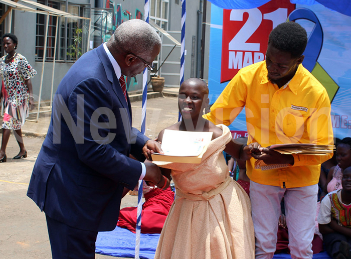  ormer rime inister mama babazi handing of a certificate to one of the models with own syndrome during the orld own syndrome day celebration at the esinger ub in the ndustrial rea hoto by eff ndrew ule
