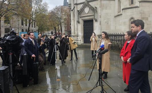 Caroline Narvaz Leite and Tom Ainsworth, from Pogust Goodhead, speak outside the High Court, London, today