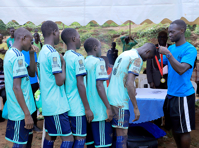  ike zira decorates the ig alent team that won the earl of frica outh occer tournament at ld ampala rimary school