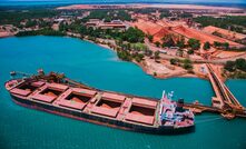 Ship being loaded at Rio Tinto Weipa operations with bauxite stockpiles in the background.